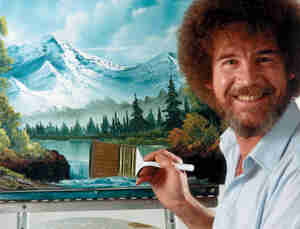Bob Ross smiling and standing before painting